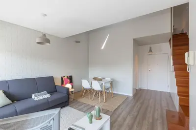 a living room with a blue couch and a table at Aposentus - Arrábida Studio in Vila Nova de Gaia