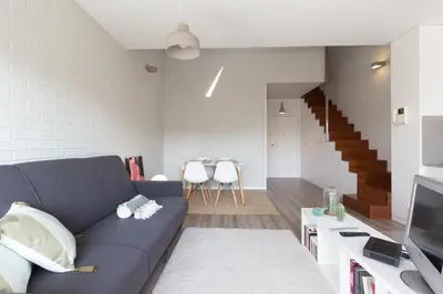 a living room with a blue couch and a staircase at Aposentus - Arrábida Studio in Vila Nova de Gaia