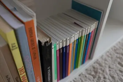 a row of books sitting on a shelf at Aposentus - Arrábida Studio in Vila Nova de Gaia