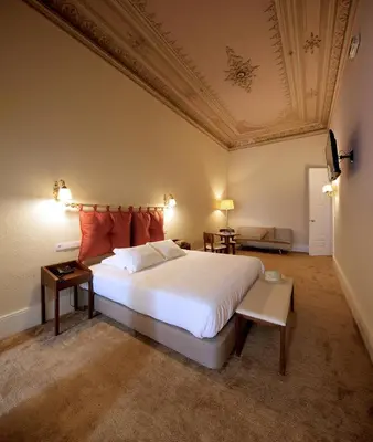 a bedroom with a large white bed and a coffered ceiling at The Rex Hotel Porto - Mansion House - Private Parking in Porto