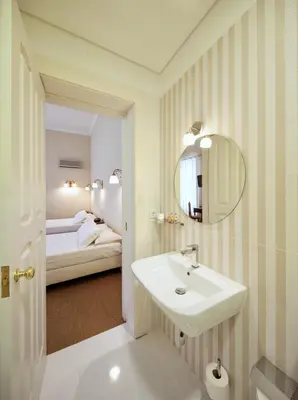 a bathroom with a sink and a mirror and a bed at The Rex Hotel Porto - Mansion House - Private Parking in Porto