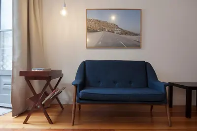 a living room with a blue chair and a table at Cale Guest House in Porto