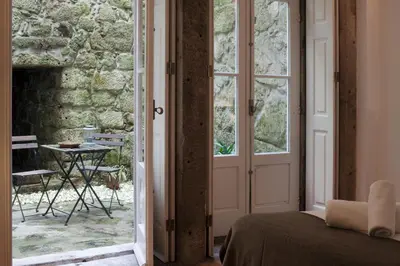 a bedroom with a door leading to a patio at Cale Guest House in Porto
