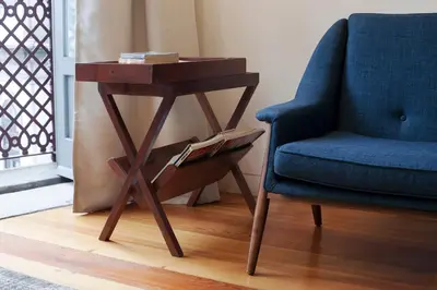 a wooden table next to a blue chair and a side table at Cale Guest House in Porto