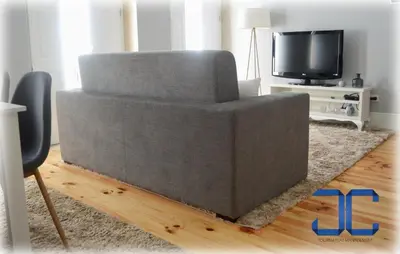 a gray couch in a living room with a tv at #Four Apartment by JC in Porto