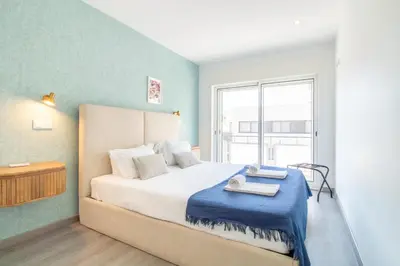 a bedroom with a large bed and a window at LovelyStay - Boavista Cozy Apartment in Porto