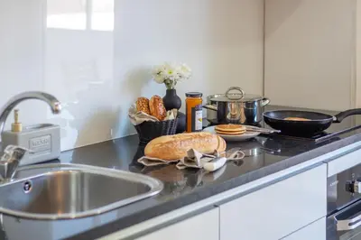 a kitchen counter with a sink with bread and a pot at LovelyStay - Boavista Cozy Apartment in Porto