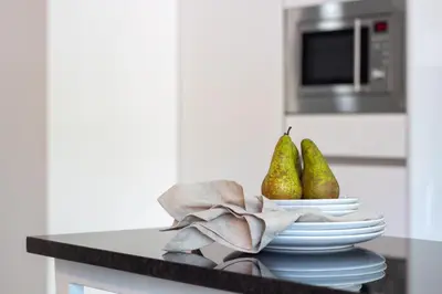 a counter with plates and pears on it in a kitchen at LovelyStay - Boavista Cozy Apartment in Porto