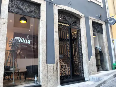 a white bedroom with a large bed and a window at Mystay Porto Batalha in Porto