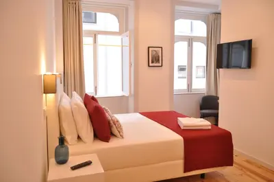a living room with white cabinets and a wooden floor at Mystay Porto Batalha in Porto