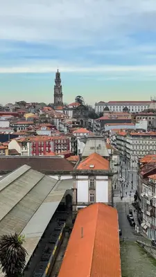two tables and chairs with an umbrella on a patio at Mystay Porto Batalha in Porto