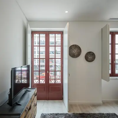 a living room with a red door and a television at Porto Deluxe Suites in Porto