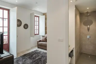 a living room with a couch and a television at Porto Deluxe Suites in Porto