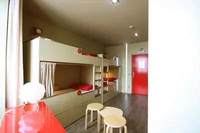 a bed with a red pillow in a room at PILOT Design Hostel & Bar in Porto