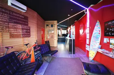 a restaurant with chairs and a surfboard on the wall at PILOT Design Hostel & Bar in Porto