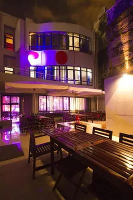 a restaurant with benches and tables in front of a building at PILOT Design Hostel & Bar in Porto