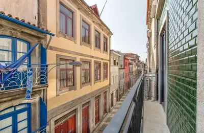 a white bedroom with a bed and a tv at Downtown Porto Flat, Walk to City Center in Porto