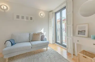 a white kitchen with a sink and a counter top at Downtown Porto Flat, Walk to City Center in Porto