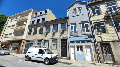 a small white car parked in front of buildings at Downtown Porto with PARKING next to subway in Porto