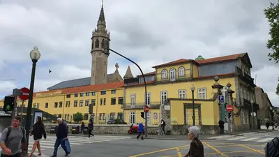 a group of people crossing a street in front of a yellow building at Downtown Porto with PARKING next to subway in Porto