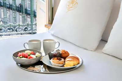 a tray of breakfast foods and coffee on a bed at One Shot Aliados Goldsmith in Porto