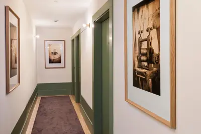 a hallway with green and white walls and paintings at One Shot Aliados Goldsmith in Porto