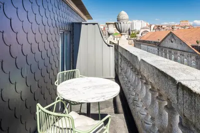 a table and two chairs sitting on a balcony at One Shot Aliados Goldsmith in Porto