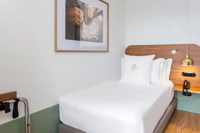 a bedroom with a white bed and a picture on the wall at One Shot Aliados Goldsmith in Porto