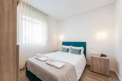 a bedroom with a large bed with two towels on it at Hotel Grande Rio in Porto