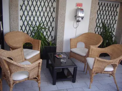 a patio with wicker chairs and a table at Hotel Grande Rio in Porto