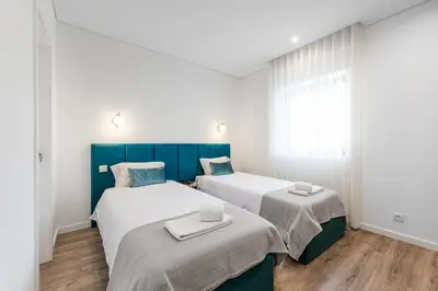 two beds in a room with white and blue at Hotel Grande Rio in Porto