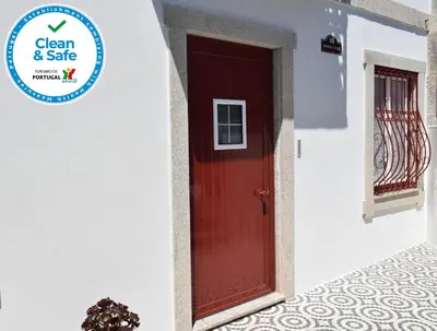 a red door on the side of a white building at Oporto Living Apartments in Porto