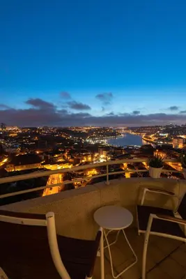 a view of a city at night with a table and chairs at Porto Gaia River View 8 by MP in Vila Nova de Gaia