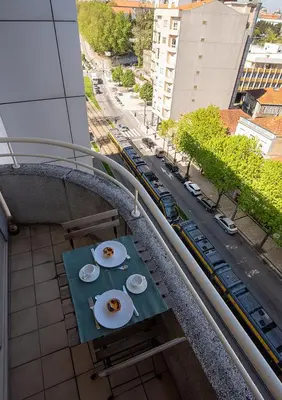 a table with two plates of food on a balcony at Porto Gaia River View 8 by MP in Vila Nova de Gaia
