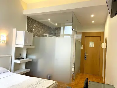 a bedroom with a white bed and a glass door at Hotel Universal in Porto