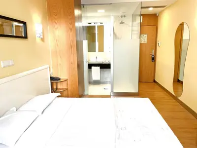 a bedroom with a white bed and a bathroom at Hotel Universal in Porto