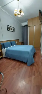a bedroom with a blue bed and a wooden floor at Residencial Sol da Nave in Porto