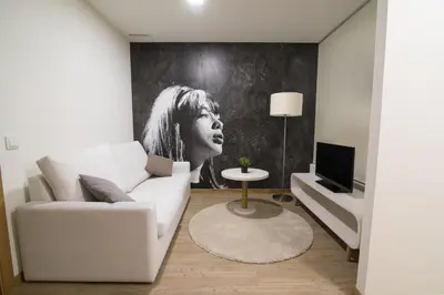 a living room with a white couch and a tv at Porto Coliseum Hotel in Porto