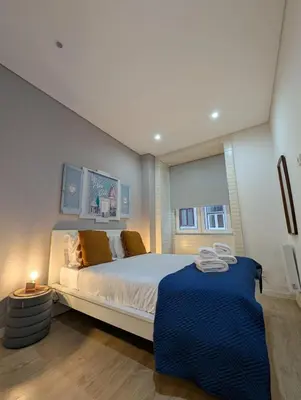 a bedroom with a large bed with a blue blanket at Calm In Formosa in Porto