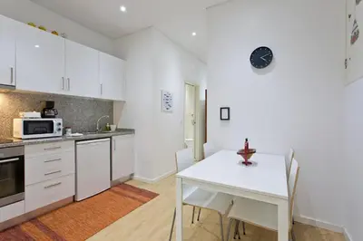 a kitchen with white cabinets and a white table at Calm In Formosa in Porto