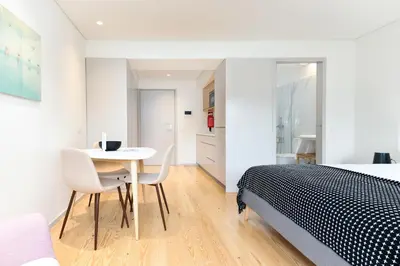 a bedroom with a bed and a table and chairs at Bom Jardim Apartments in Porto