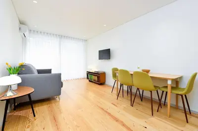 a living room with a table and yellow chairs at Bom Jardim Apartments in Porto