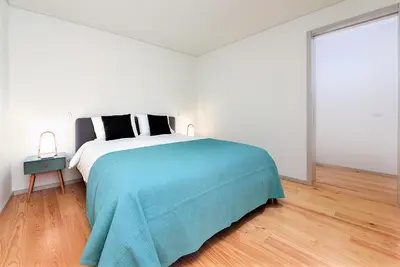 a white bedroom with a bed with a blue blanket at Bom Jardim Apartments in Porto