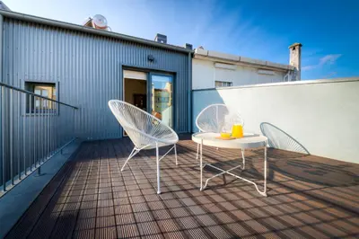 a patio with two chairs and a table on a balcony at Bom Jardim Apartments in Porto