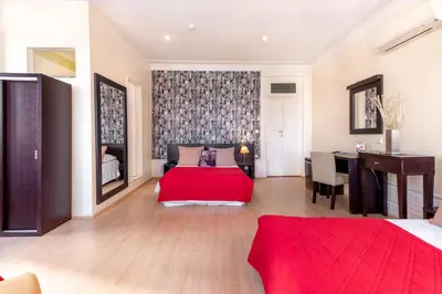 a bedroom with a red bed and a desk at Hotel do Norte in Porto