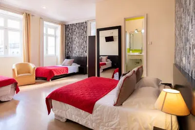a bedroom with a bed and a couch and a mirror at Hotel do Norte in Porto