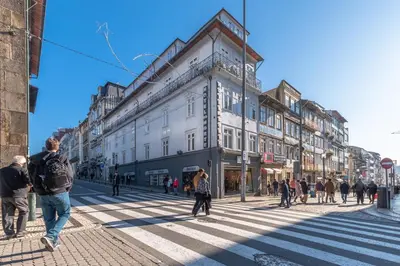 a group of people walking on a city street at Hotel do Norte in Porto
