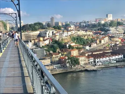 a person walking on a bridge over a river at Sé Boutique Apartment in Porto