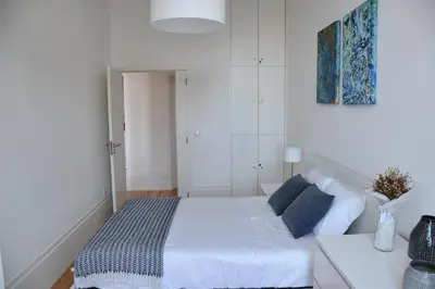 a white bedroom with a bed and a table at Sé Boutique Apartment in Porto