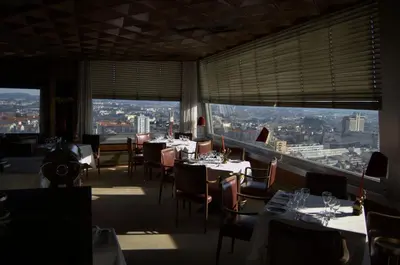 a restaurant with tables and chairs and large windows at Hotel Miradouro in Porto